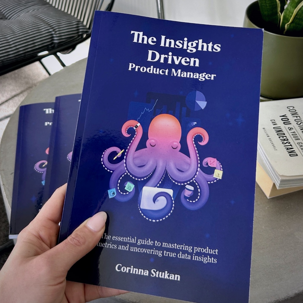 Corinna holding a copy of her book, The Insights Driven Product Manager